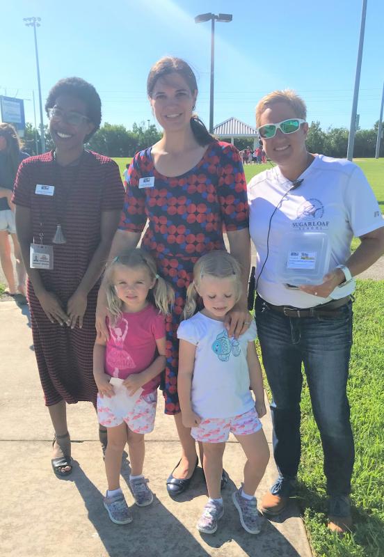 Sugarloaf VPK students help the Assistant Principal accept the Tools for Back to School gift cards.